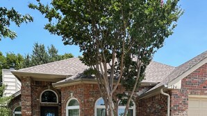 A brick house with a front door, arched windows, and a tree in the yard. - Five star ratings! Pet Friendly! Lovely Rockwall home near The Harbor! ⛴️🐡 (Rockwall)