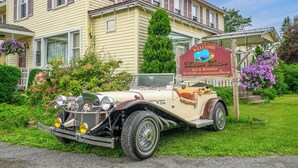 A vintage car parked in front of a yellow building with a sign reading "Welcome Mountain Treasure Bed & Breakfast." - Americana Room. Elegant room with a King-Size bed, en suite bathroom, and mountain views. Sleeps 2. <br>A gourmet breakfast is FREE and served fresh each morning.<br>Americana Room is located on the second floor of Mountain Treasure Bed and Breakfast (Maplecrest)