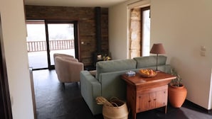 A modern living room with a green sofa, a wooden coffee table, and a fireplace. - Quinta Vila Rachel (Alijó)