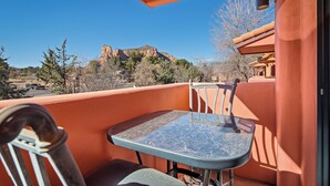 A balcony with a table and chairs, overlooking a mountainous landscape. - Bell Rock Vista - Hot Tub, Spacious Townhouse with Great Location and Views (Sedona)