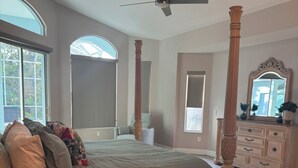 A spacious bedroom with a large bed, a ceiling fan, and a wooden dresser. - Port Boujee: Spacious 5-bedroom house in Port Charlotte with Pool, AC, WiFi (Port Charlotte)