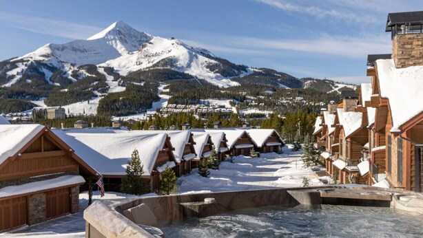 A snow-covered mountain resort with wooden cabins and a hot tub area. - Amazing Views - Close to it All! (Big Sky)
