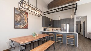 A modern kitchen with a central island, bar stools, and pendant lighting. - Amazing Views - Close to it All! (Big Sky)