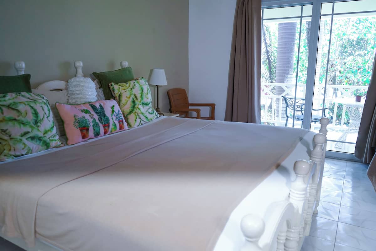 Habitación de hotel con una cama grande, una silla y vistas al exterior.