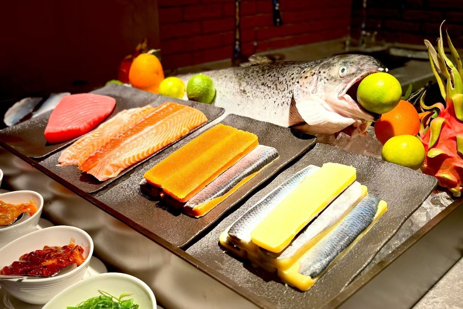 Um bar de sushi com diversos tipos de peixe e frutas.