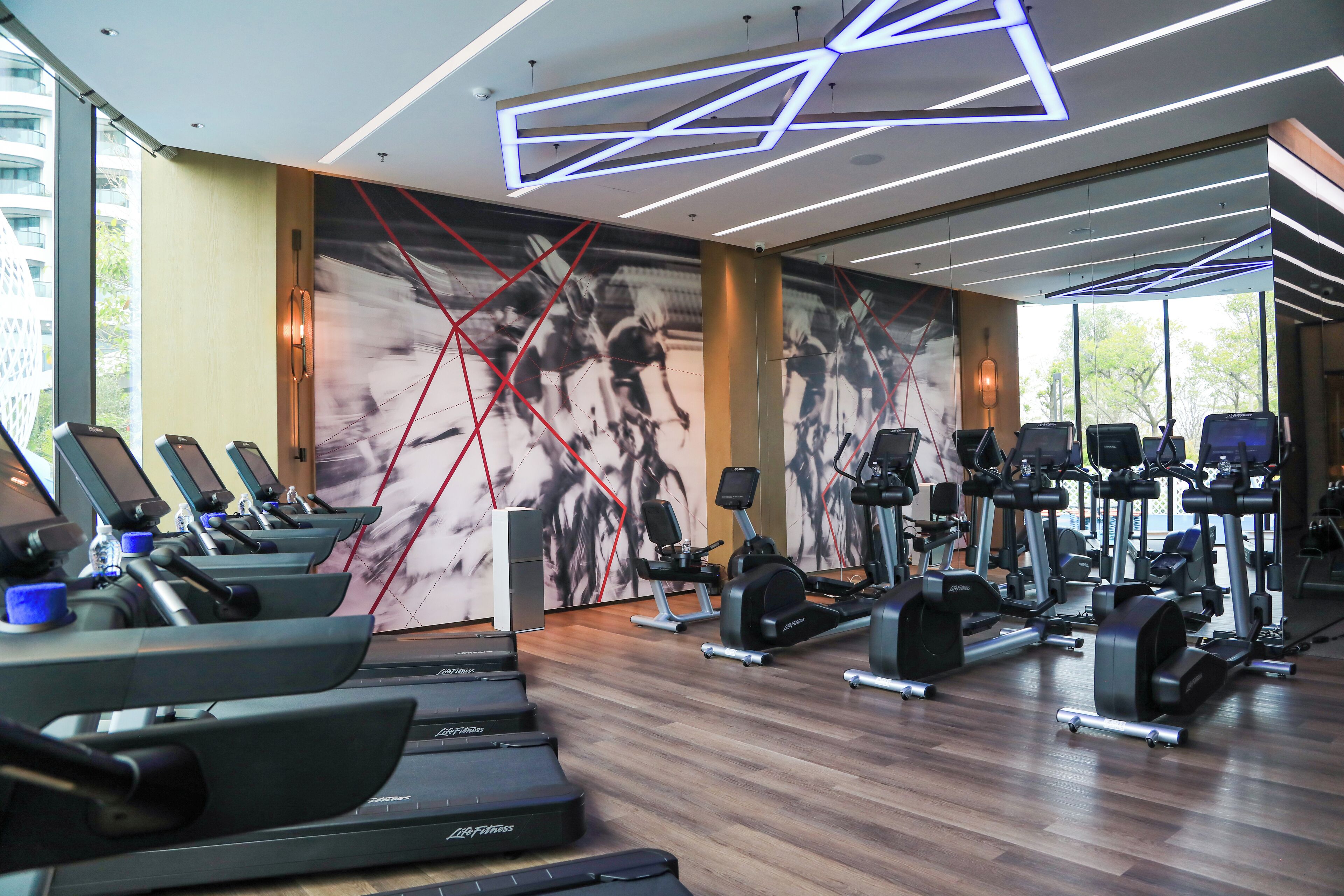 A gym with treadmills, elliptical machines, and weight equipment.