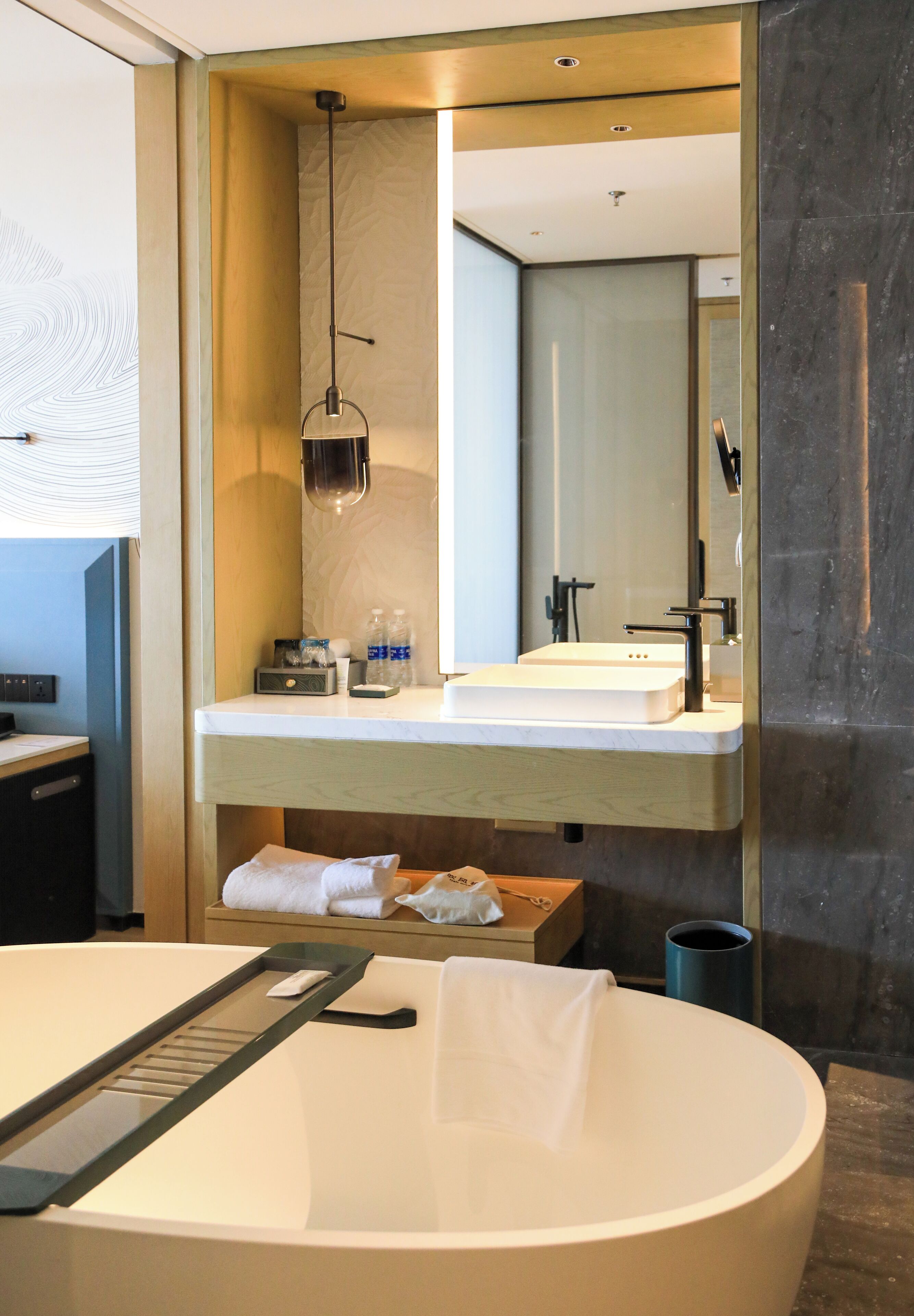 Un baño moderno con una bañera independiente, un tocador con espejo y un perchero para toallas.