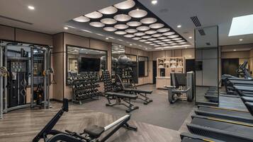 A modern gym with treadmills, weight machines, and free weights.