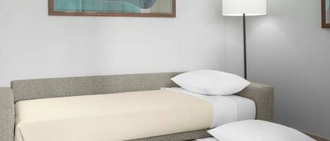 Una cama bien hecha con un cabecero gris, una almohada blanca y otra almohada blanca sobre la cama.