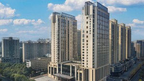 Un edificio alto con múltiples pisos, ventanas amplias y una entrada destacada.
