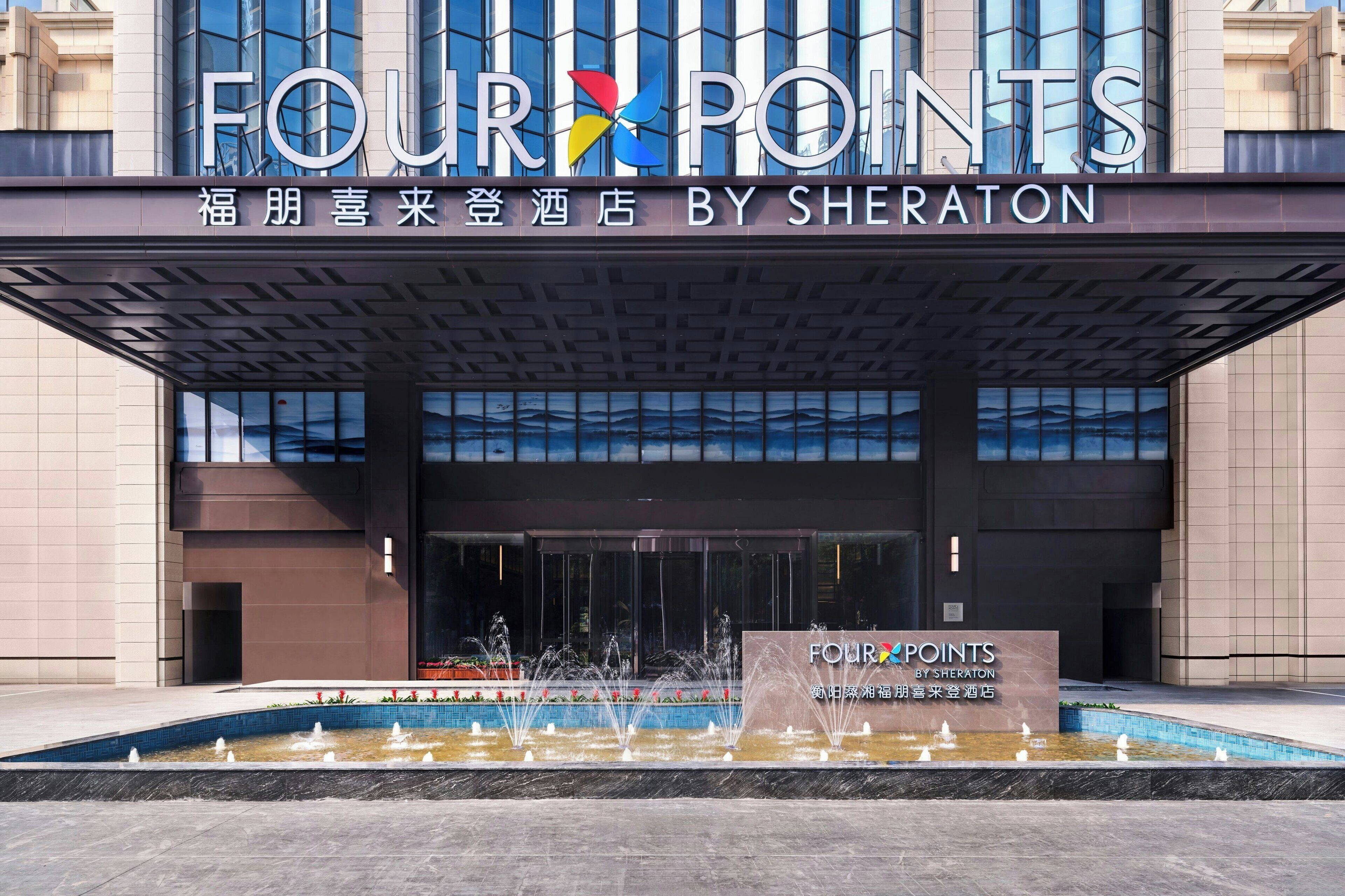 The exterior of the Four Points by Sheraton hotel with a fountain in front.