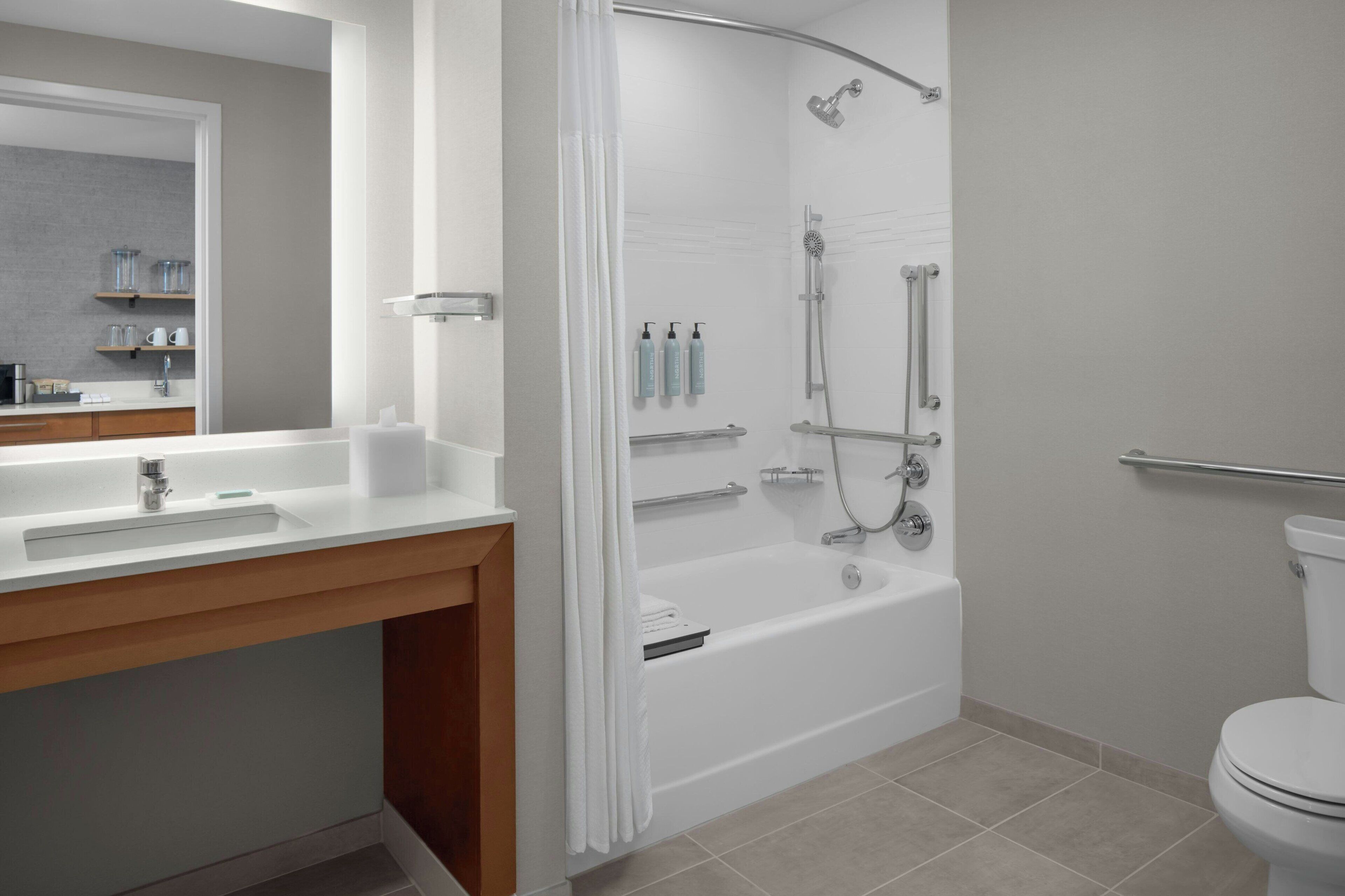 Un baño moderno con bañera, ducha e inodoro.