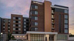 Un hotel de varios pisos con un llamativo letrero de "Residence Inn by Marriott", amplias ventanas y un diseño arquitectónico moderno.