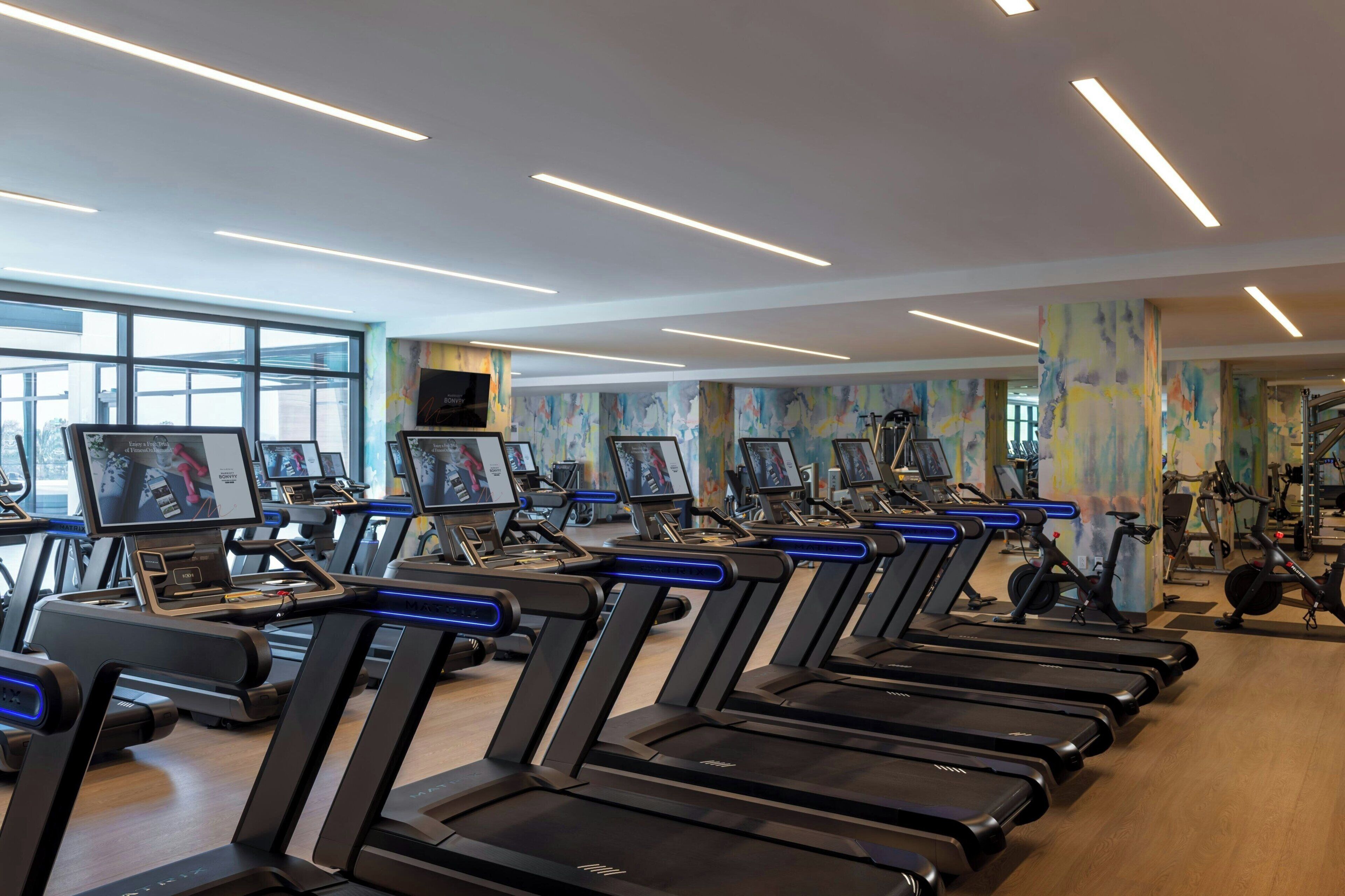 A gym with multiple treadmills, stationary bikes, and exercise equipment.