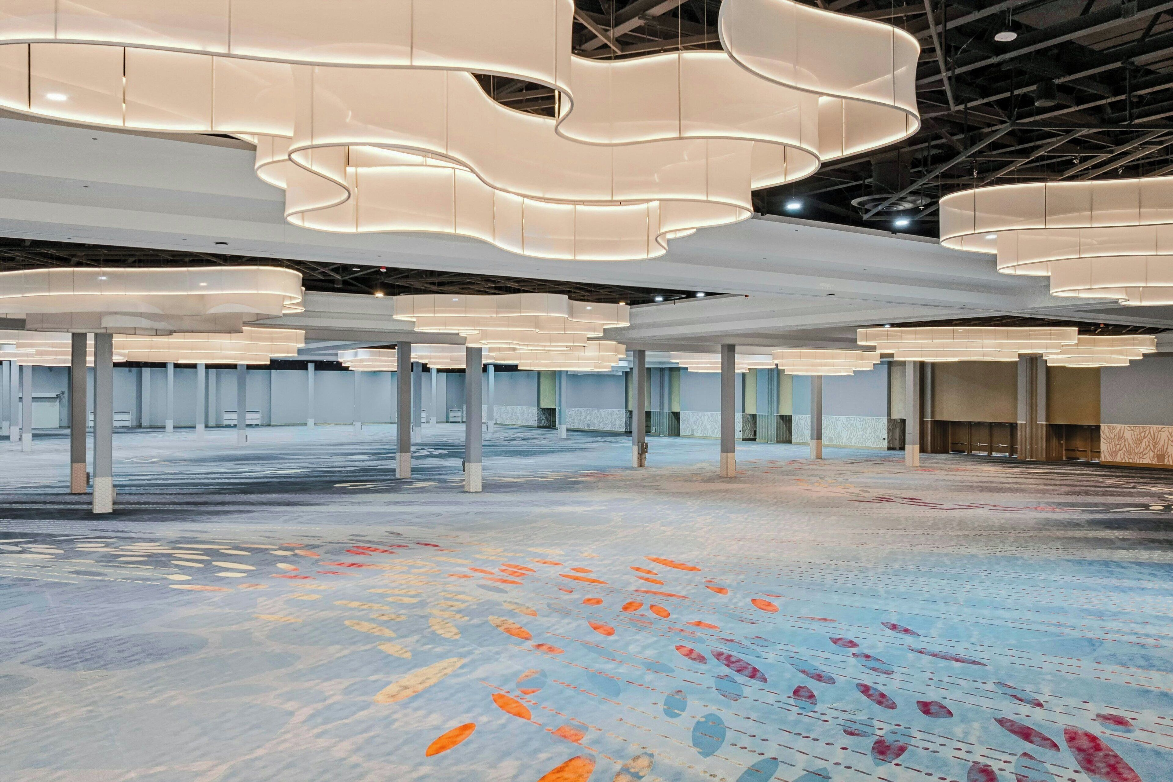A spacious indoor area with a modern ceiling design and a patterned floor.