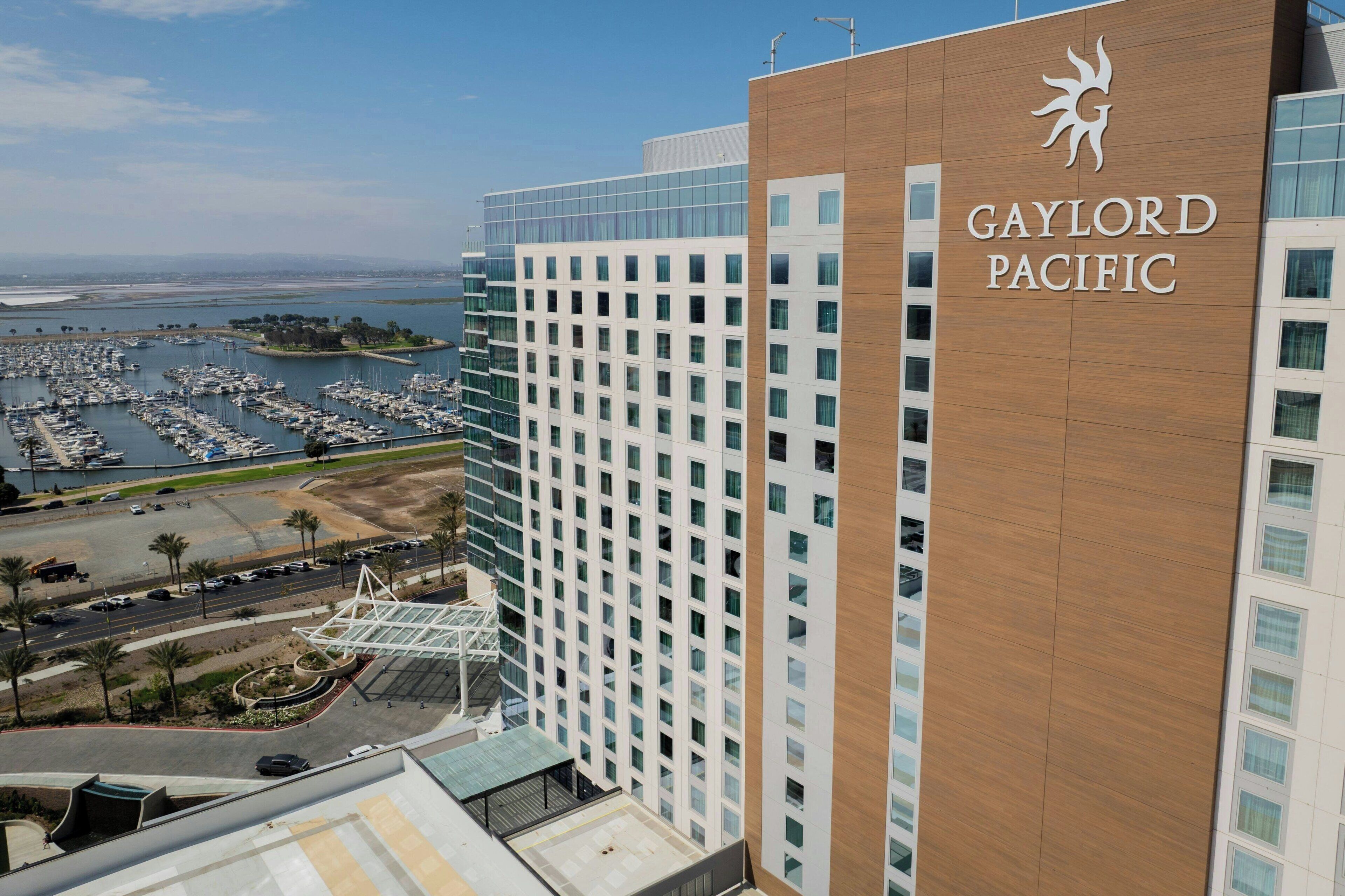 A high-rise hotel with a modern design, featuring a prominent logo on the facade.
