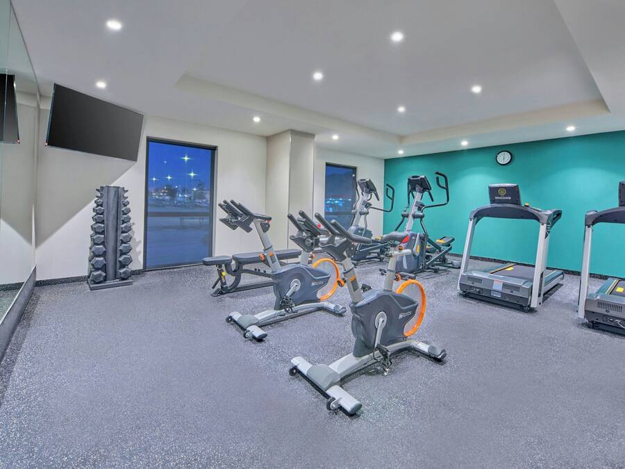 Ein Fitnessraum mit Ergometer, Laufbändern und einer Spiegelwand.