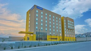 Ein City Express Hotel mit modernem Design, erkennbar an der auffälligen gelben Fassade und den zahlreichen Fenstern.