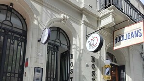A hostel with a large arched entrance, a sign reading "Why Not Hostel", and another sign for "Hooligans". - Hostel Why not nva (Córdoba)