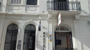 A white building with a sign reading "HOSTEL" indicating it is a lodging facility. - Hostel Why not nva (Córdoba)