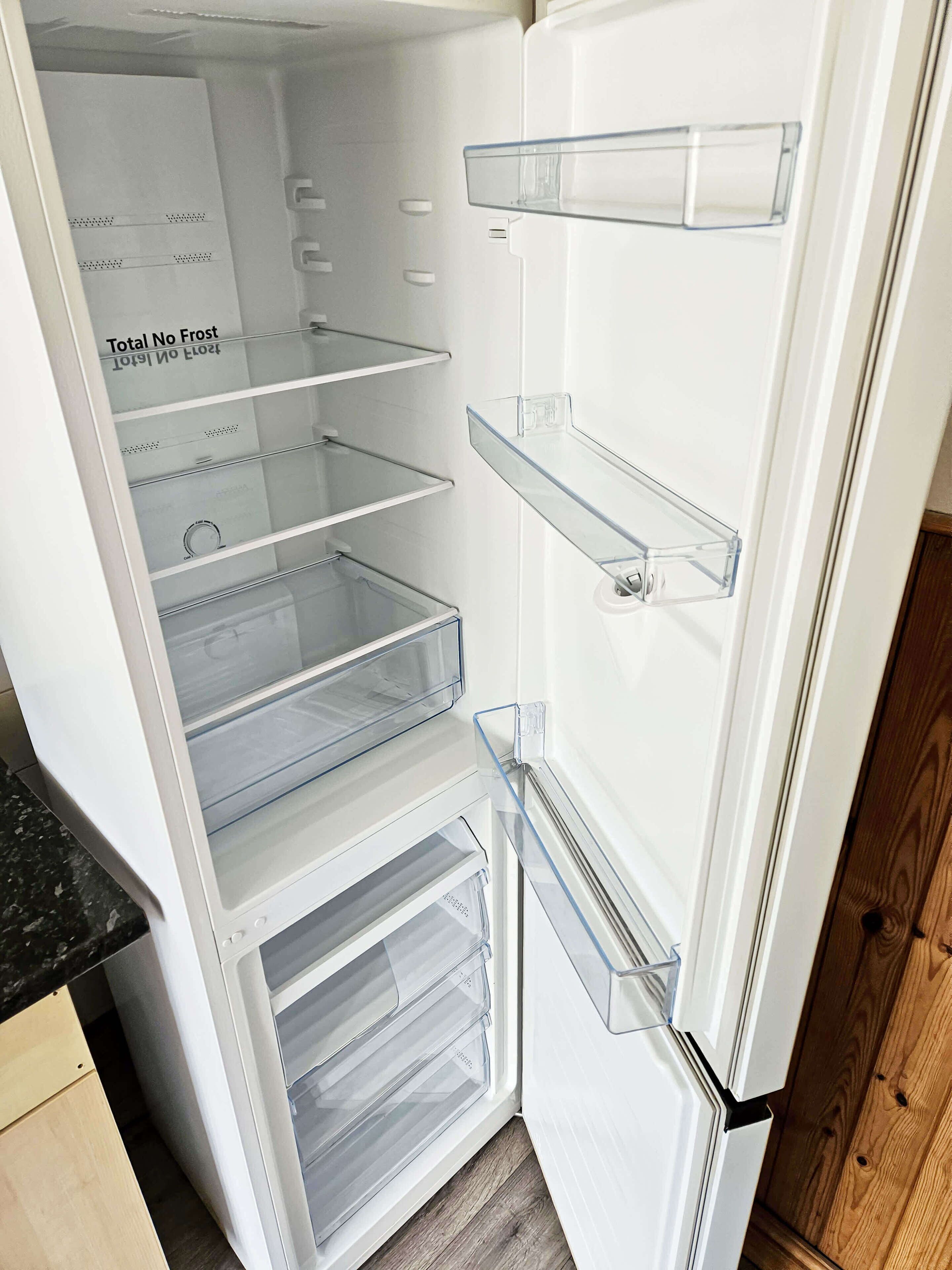 A white refrigerator with multiple shelves and a freezer compartment.