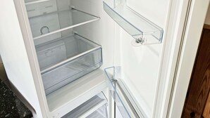 A white refrigerator with multiple shelves and a freezer compartment.