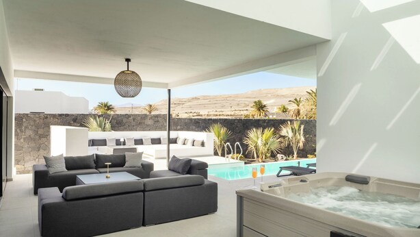 A modern outdoor living area with a sofa set, a hot tub, and a pool. - ODIN 2 by Buenavilla | Experience Unmatched Luxury in Puerto Calero (Puerto Calero)