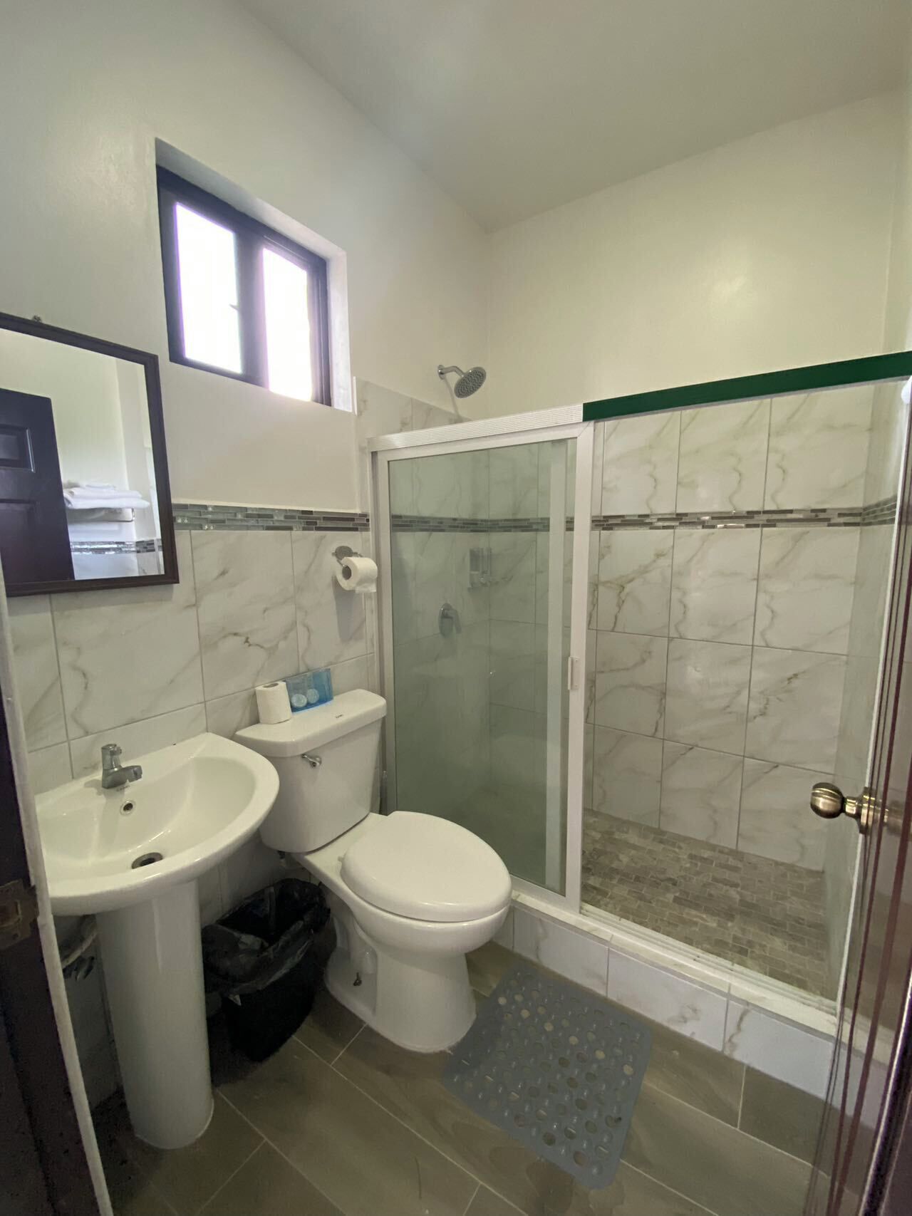 A bathroom with a sink, toilet, and glass-enclosed shower.