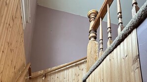 Una escalera de madera con peldaños alfombrados y barandilla.
