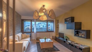Un salon moderne avec un canapé, une table basse et un téléviseur fixé au mur.
