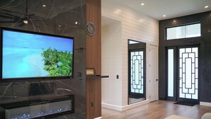 Una sala de estar moderna con televisor de pantalla plana, paneles de madera y un acuario.