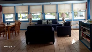 A living room with a sofa, chairs, a dining table, and a bookshelf. - Charming Standalone 3-bedroom villa with AC and WiFi in lovely Frigate Bay (Frigate Bay)