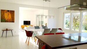 A modern dining area with a large table, chairs, and a television in the background. - 165m² Exclusive Villa on 1200m² 15mins from Berlin (Brieselang)