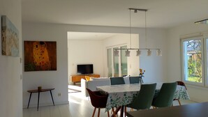 A modern dining area with a table, chairs, and a television in the background. - 165m² Exclusive Villa on 1200m² 15mins from Berlin (Brieselang)