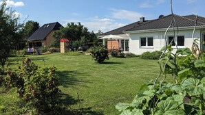 A residential property with a well-maintained lawn, a playhouse, and a barbecue area. - 165m² Exclusive Villa on 1200m² 15mins from Berlin (Brieselang)