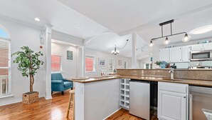 A modern kitchen with white cabinetry, a granite countertop, and stainless steel appliances.