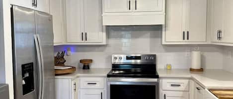 Microondas, parrilla de estufa, utensilios de cocina y comedor