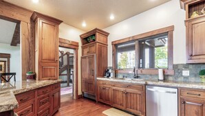 A kitchen with wooden cabinets, granite countertops, and a dishwasher.