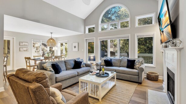 A spacious living room with a high ceiling, large windows, and a fireplace. - Palmetto Dunes 2BR Pet Friendly Condo with Balcony and Beach Access! (Hilton Head Island)