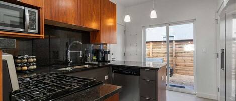A modern kitchen with wooden cabinets, stainless steel appliances, and a large island.