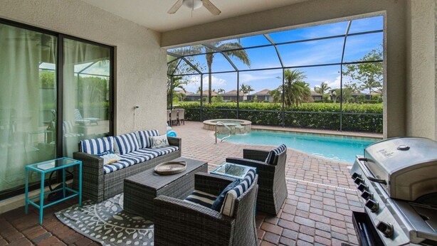 Une terrasse avec une piscine, du mobilier d’extérieur et un barbecue.