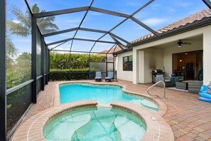 Ein Pool mit Whirlpool, Liegestühlen und einer überdachten Terrassenbereiches.