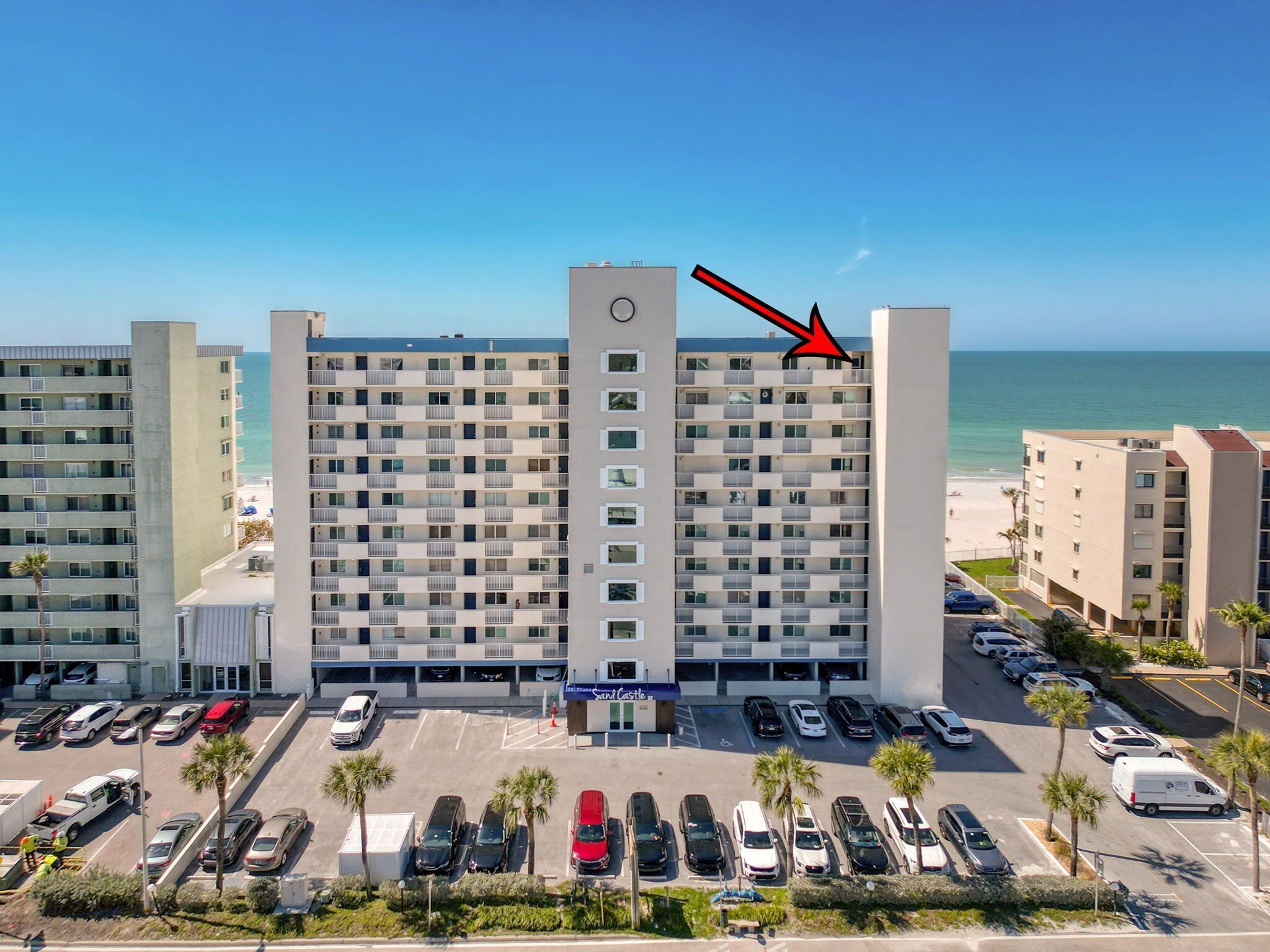 A multi-story hotel with a parking lot in front.