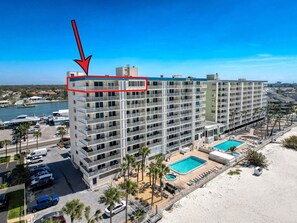 Un hôtel à plusieurs étages doté de balcons, d’une piscine et offrant une vue sur la plage.