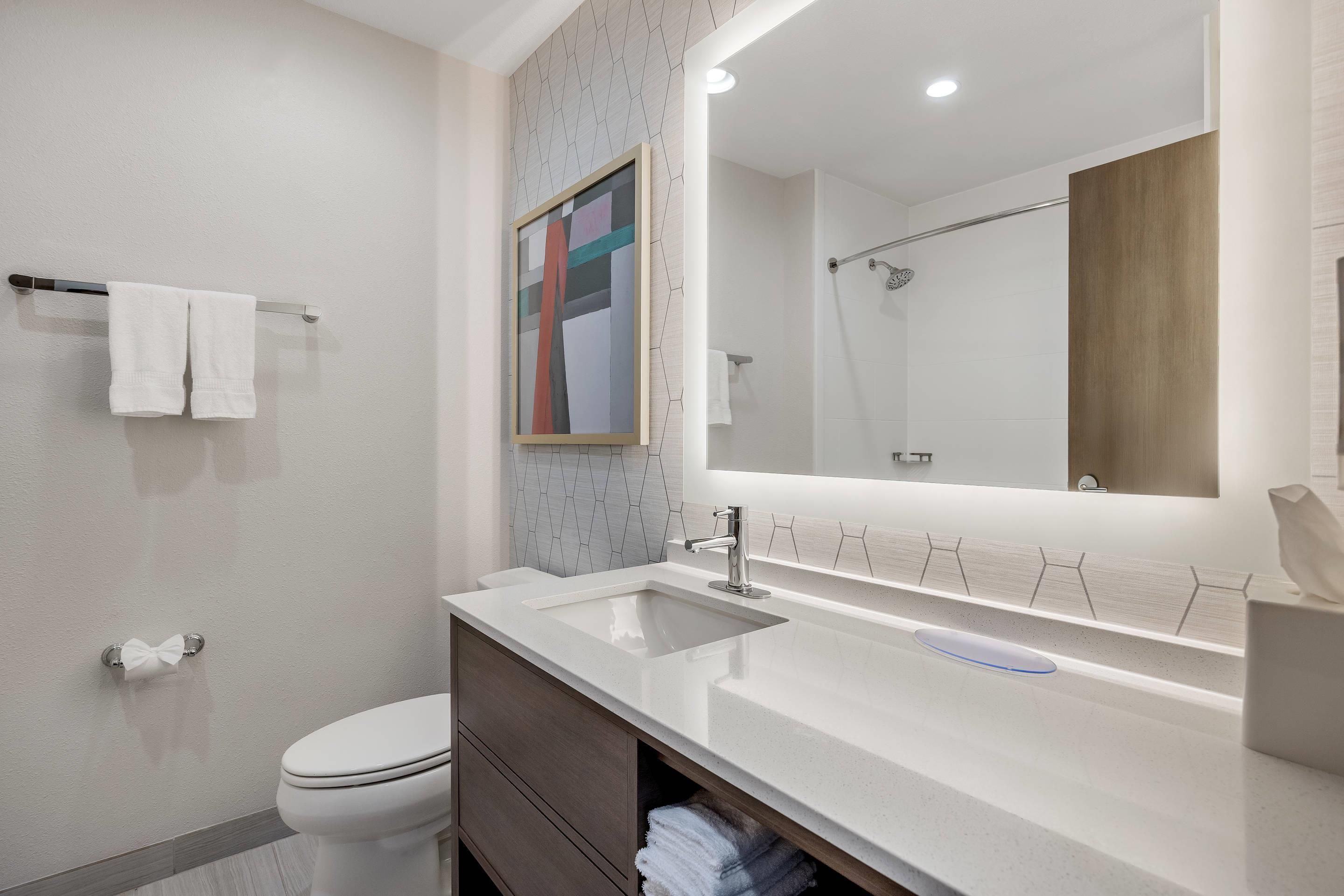 Een moderne badkamer met toilet, wastafel en douche.