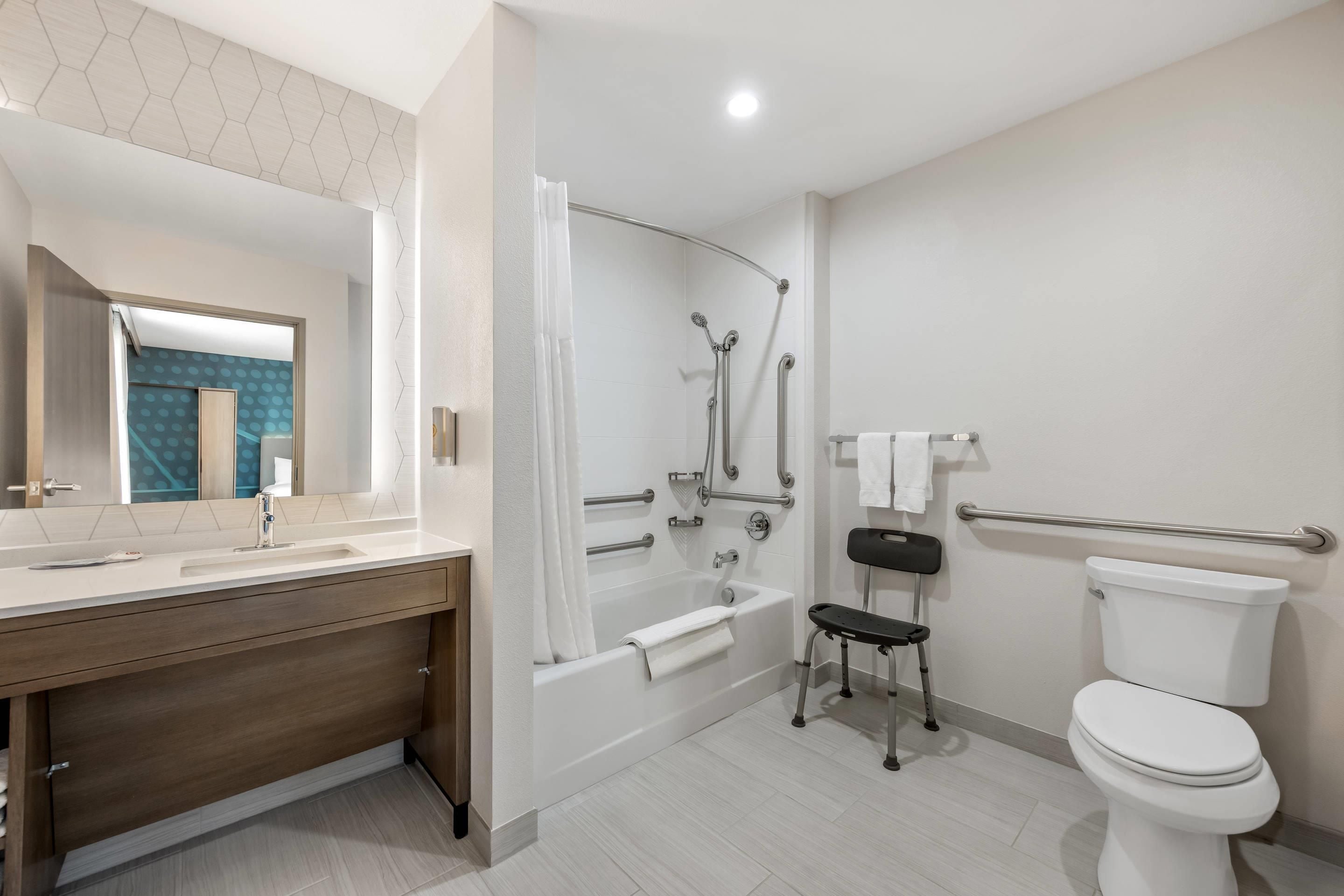 A modern bathroom with a bathtub, toilet, and shower.
