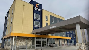 A Comfort Inn & Suites hotel with a stone facade, large windows, and a covered entrance. - Comfort Inn & Suites Colby (Colby)