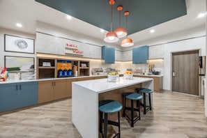 A modern kitchen with a central island, bar stools, and a coffee station. - Comfort Inn & Suites Colby (Colby)