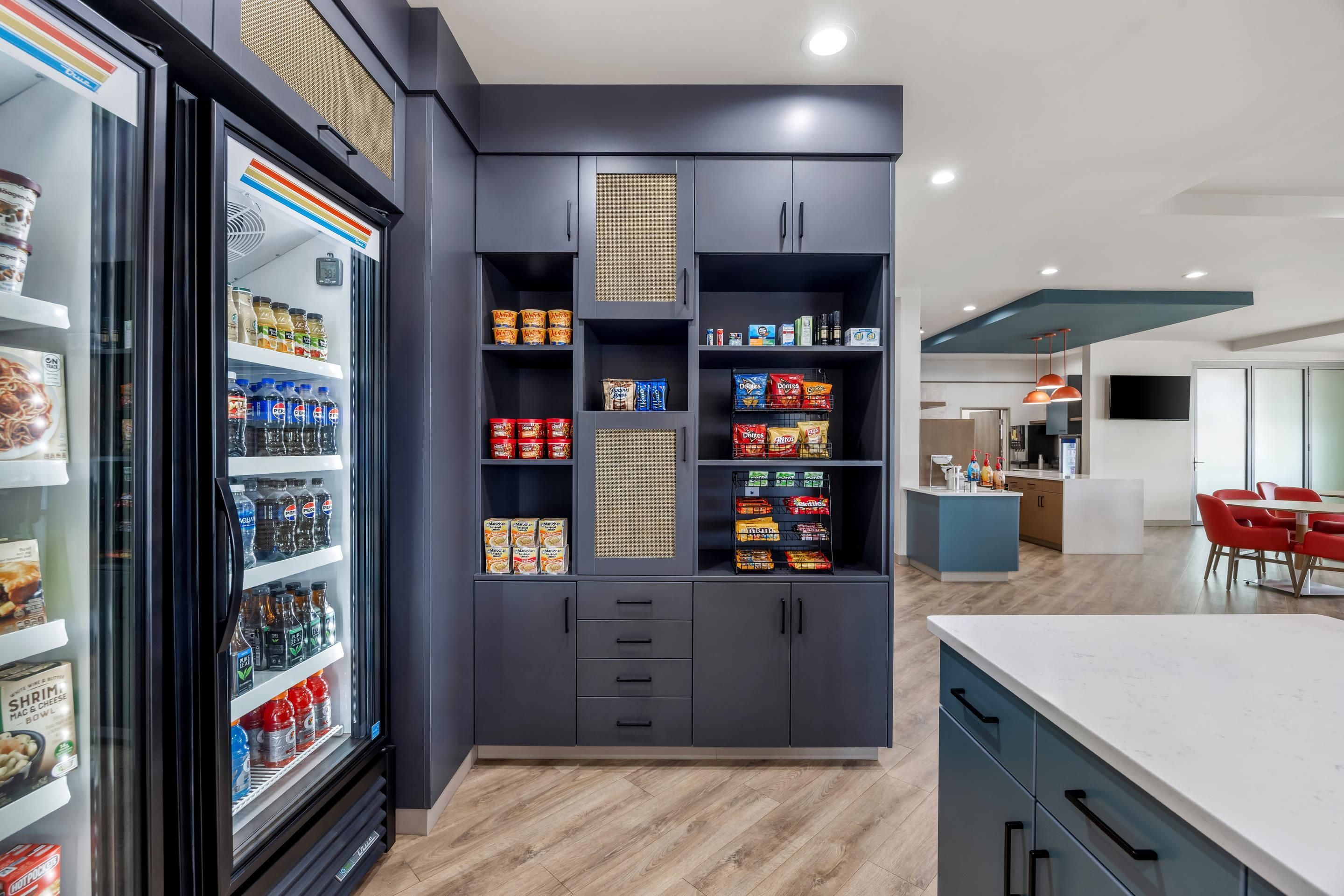 Una cocina moderna con armarios empotrados, un refrigerador y un comedor con mesa y sillas.