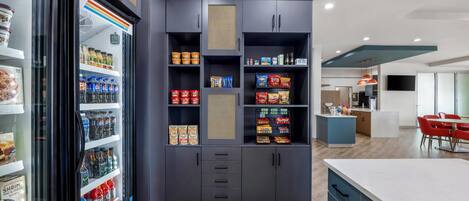 Una cocina moderna con armarios empotrados, un refrigerador y un comedor con mesa y sillas.
